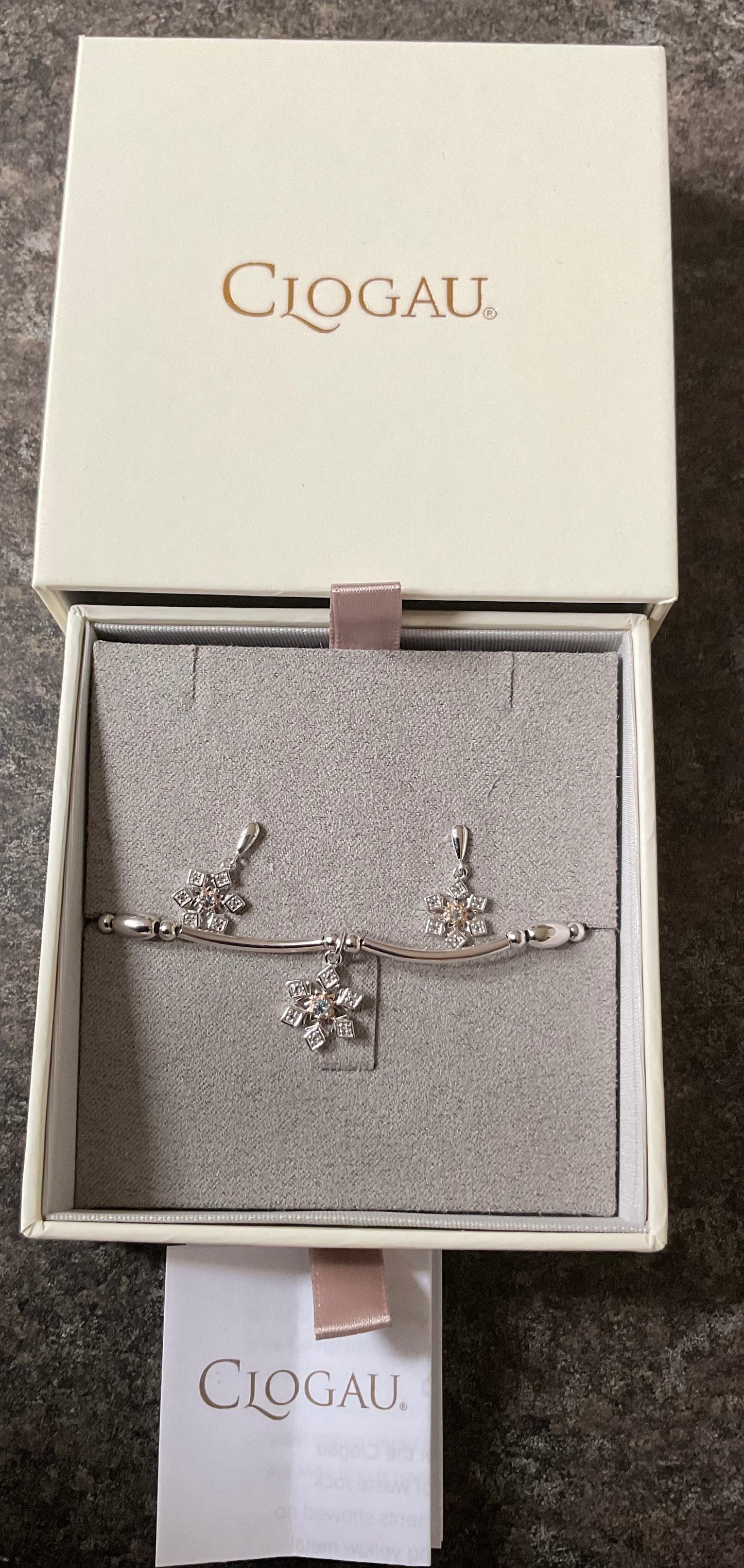 Clogau Snowflake drop earrings and Snowflake affinity stacking bracelet in silver and rose gold with white topaz