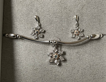 Clogau Snowflake drop earrings and Snowflake affinity stacking bracelet in silver and rose gold with white topaz