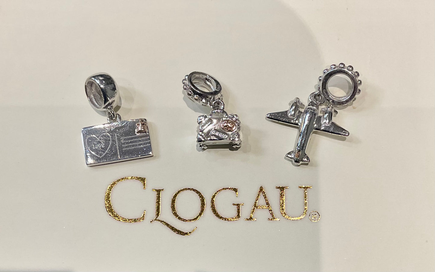 Clogau Suitcase, Postcard and Aeroplane Milestones charms in Silver and rose gold