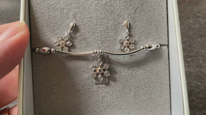 Clogau Snowflake drop earrings and Snowflake affinity stacking bracelet in silver and rose gold with white topaz